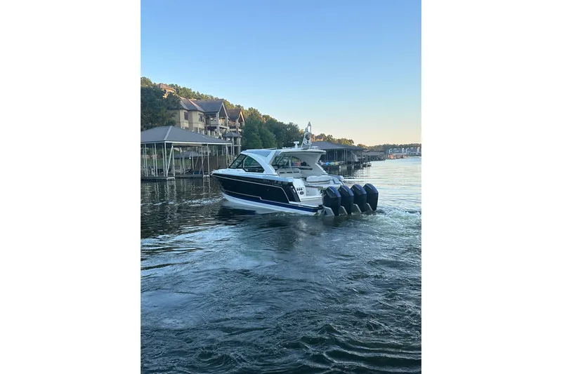 Sea Winds Yacht Photos Pics 2020 Formula 400 Super Sport Crossover boat cruising on a serene lake near docks.