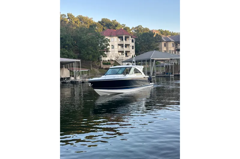 Sea Winds Yacht Photos Pics 2020 Formula 400 Super Sport Crossover boat on a serene lake near luxury homes.