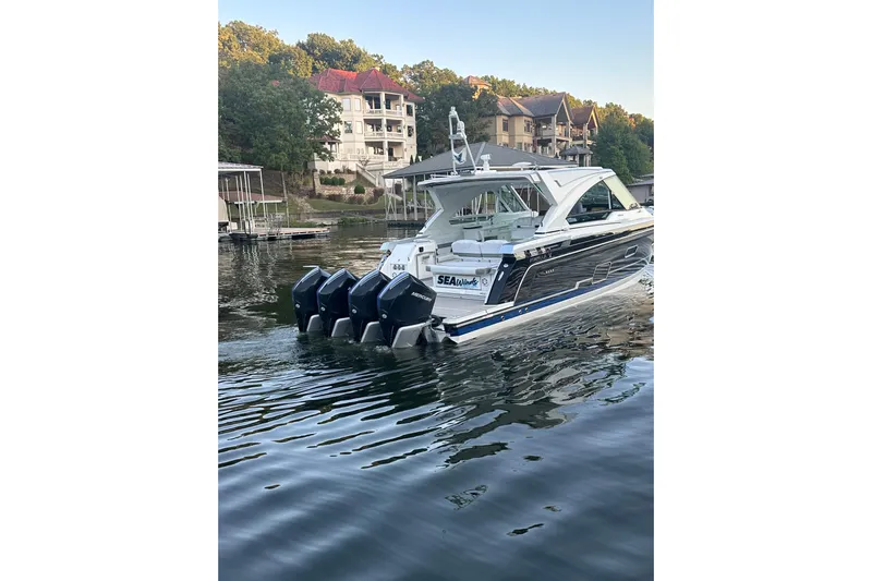 Sea Winds Yacht Photos Pics 2020 Formula 400 Super Sport Crossover boat on a serene lake near luxury homes.