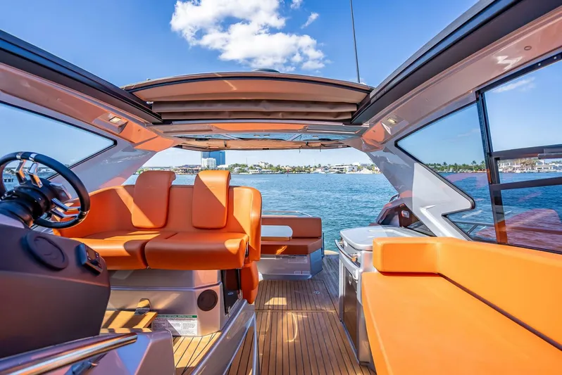 Namaste Yacht Photos Pics 2021 Cranchi M44 yacht interior with orange seating, open roof, and ocean view.