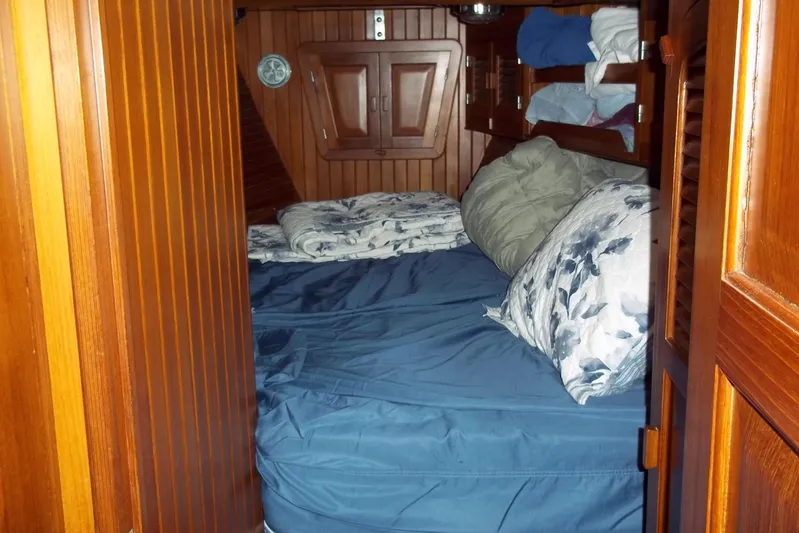 Trouvaille Yacht Photos Pics Cozy cabin interior of 1984 Slocum 43 sailboat with wooden paneling and bedding.