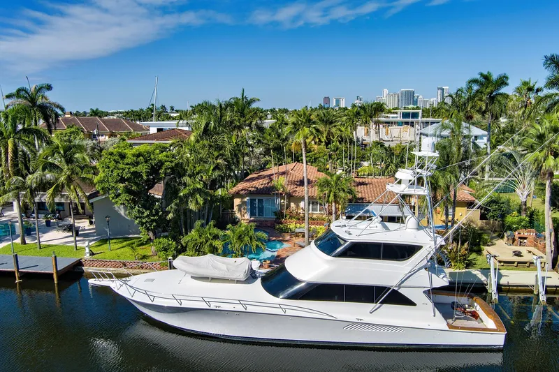  Yacht Photos Pics Luxury 2008 Viking 74 Enclosed Bridge yacht docked by tropical waterfront property.