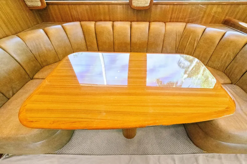  Yacht Photos Pics Luxurious dining area in 2008 Viking 74 Enclosed Bridge yacht with polished wood table.
