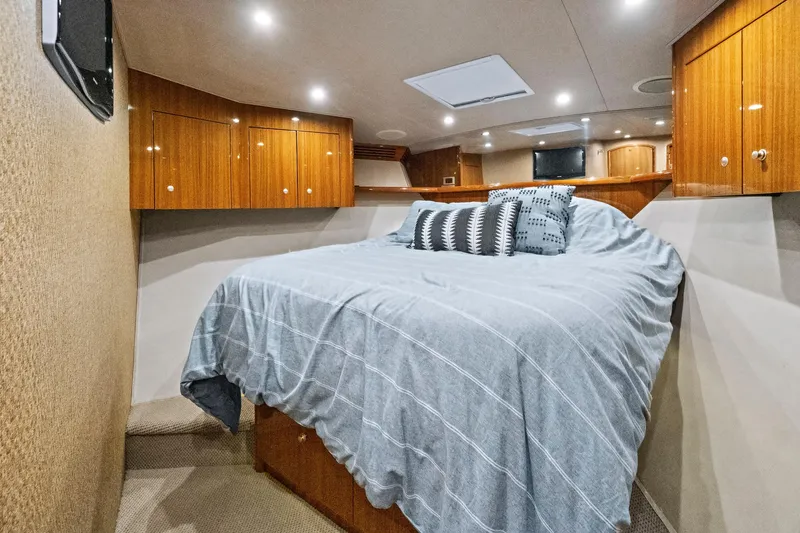  Yacht Photos Pics Luxurious bedroom interior of 2008 Viking 74 Enclosed Bridge yacht with wood cabinets.