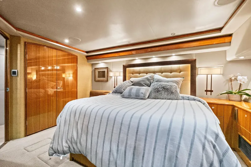  Yacht Photos Pics Luxurious bedroom interior of 2008 Viking 74 Enclosed Bridge yacht with elegant wood finishes.