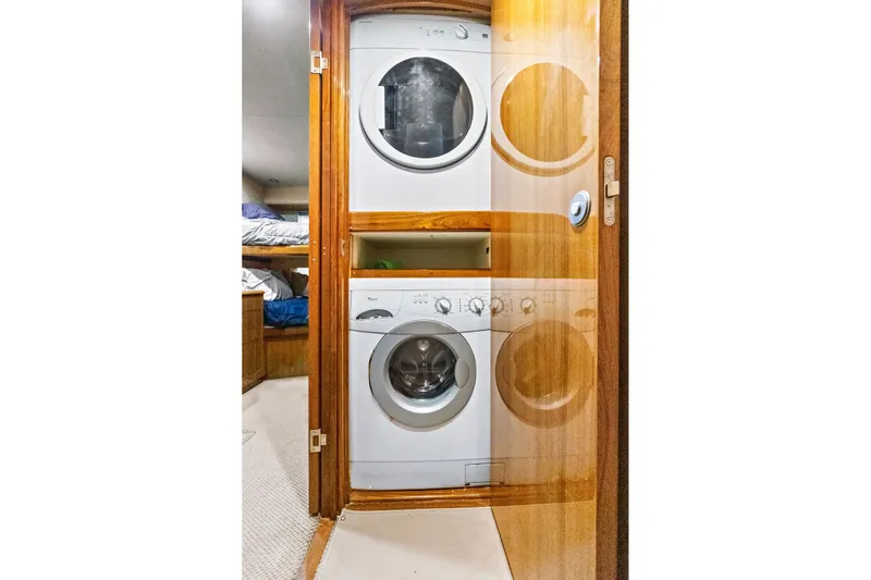  Yacht Photos Pics Laundry area with stacked washer and dryer in 2008 Viking 74 Enclosed Bridge yacht.