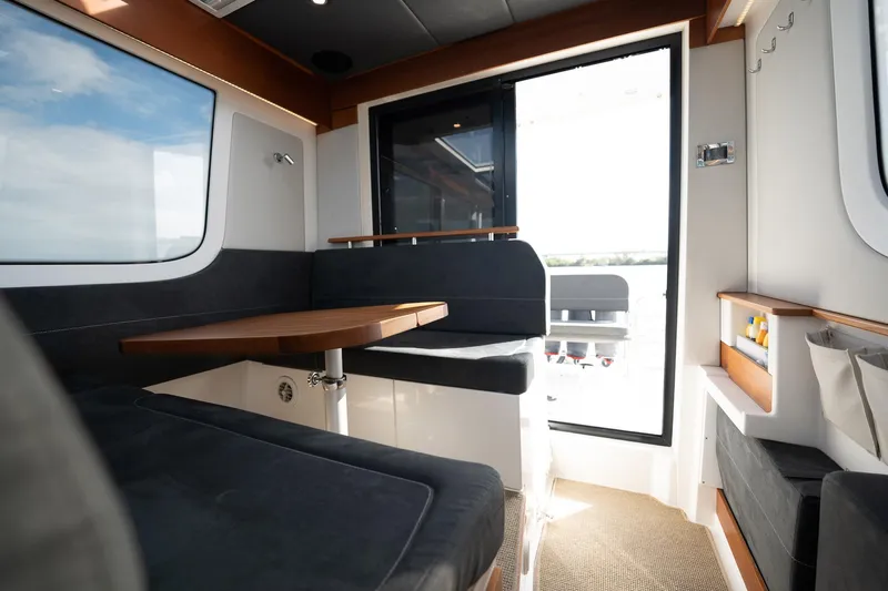 Lady Lindy Yacht Photos Pics Interior of 2021 Nimbus C-11 boat with modern seating and wooden table.