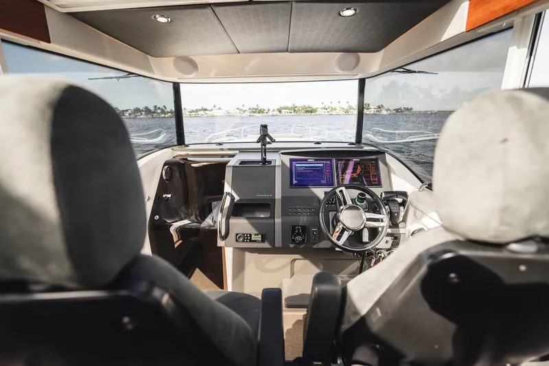 Lady Lindy Yacht Photos Pics Interior view of 2021 Nimbus C-11 boat cockpit with steering wheel and navigation screens.