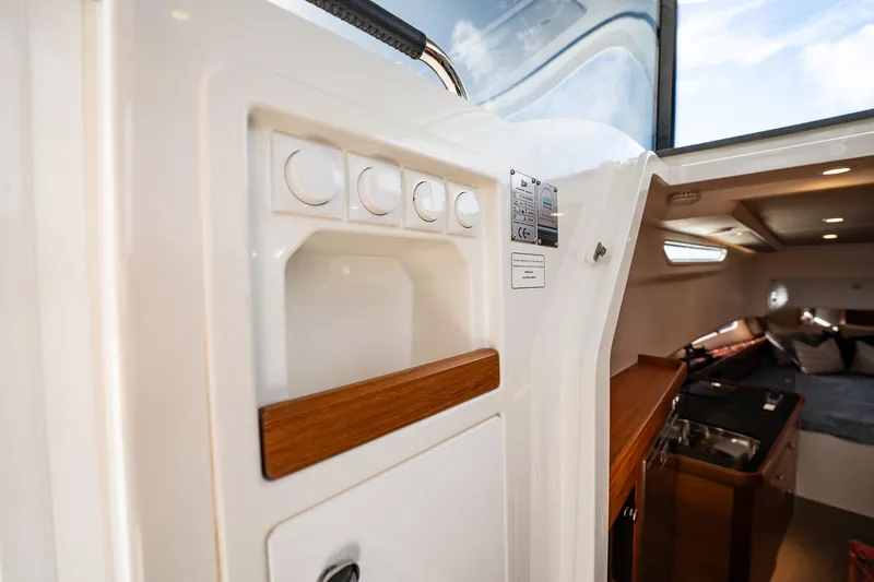 Lady Lindy Yacht Photos Pics Interior view of 2021 Nimbus C-11 boat, featuring control panel and cozy cabin area.