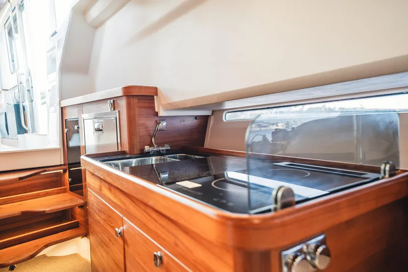 Lady Lindy Yacht Photos Pics Luxurious wooden kitchen interior in 2021 Nimbus C-11 boat, featuring modern appliances and sleek design.