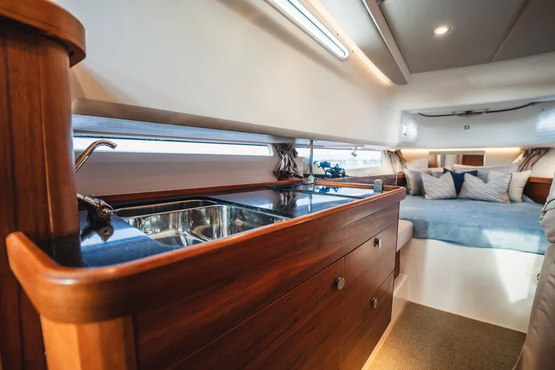 Lady Lindy Yacht Photos Pics Luxurious interior of 2021 Nimbus C-11 yacht with wooden cabinetry and cozy sleeping area.
