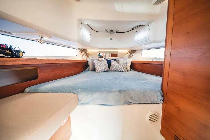 Lady Lindy Yacht Photos Pics Cozy cabin interior of 2021 Nimbus C-11 boat with plush bedding and wooden accents.
