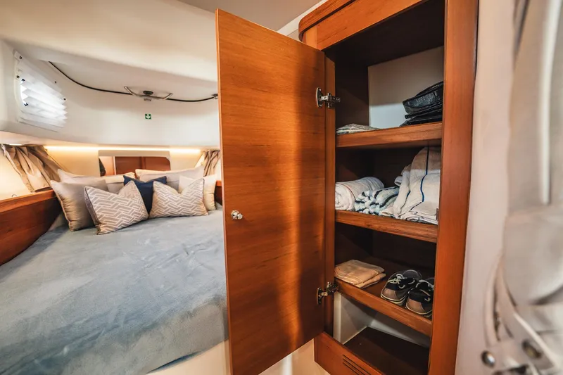 Lady Lindy Yacht Photos Pics Luxurious cabin interior of 2021 Nimbus C-11 with cozy bed and wooden wardrobe.