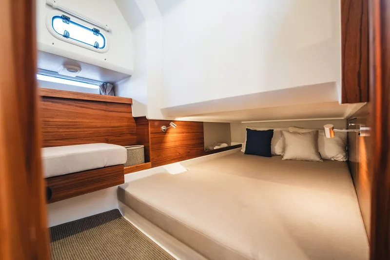 Lady Lindy Yacht Photos Pics Luxurious cabin interior of 2021 Nimbus C-11 boat with cozy bedding and wooden accents.
