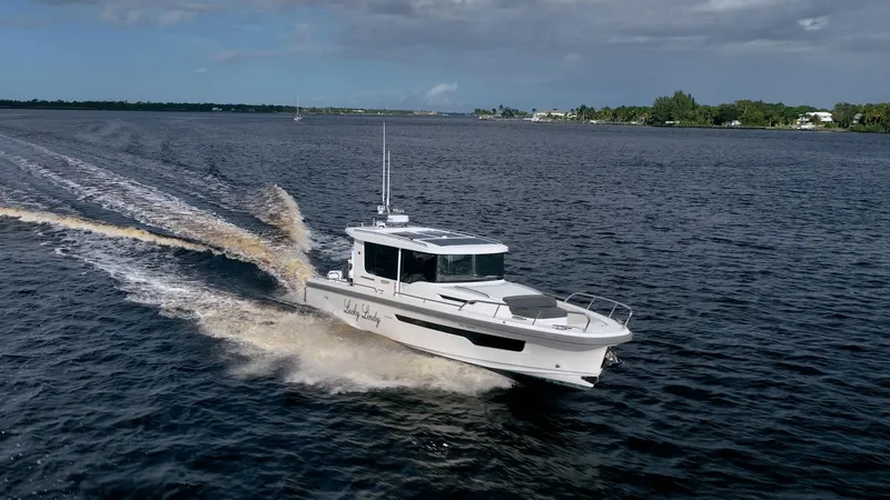 Lady Lindy Yacht Photos Pics Nimbus C-11 2021 boat cruising on open water under a partly cloudy sky.
