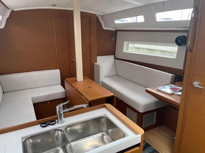 Resfeber Yacht Photos Pics Interior of 2023 Jeanneau Sun Odyssey 380 yacht with modern seating and kitchen area.