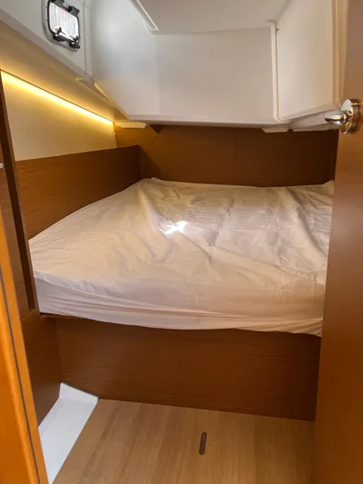 Resfeber Yacht Photos Pics 2023 Jeanneau Sun Odyssey 380 cabin interior with cozy bed and wooden finish.