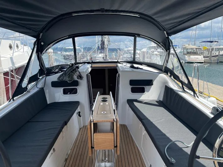 Resfeber Yacht Photos Pics 2023 Jeanneau Sun Odyssey 380 cockpit with seating, table, and canopy in marina.