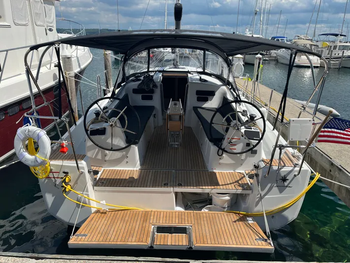 Resfeber Yacht Photos Pics 2023 Jeanneau Sun Odyssey 380 sailboat docked, featuring dual steering wheels and teak deck.