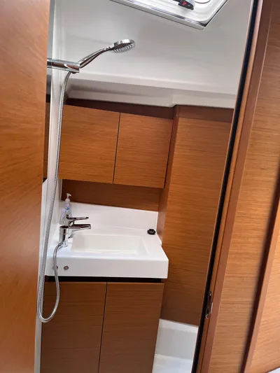 Resfeber Yacht Photos Pics 2023 Jeanneau Sun Odyssey 380 bathroom with wooden cabinets and modern fixtures.