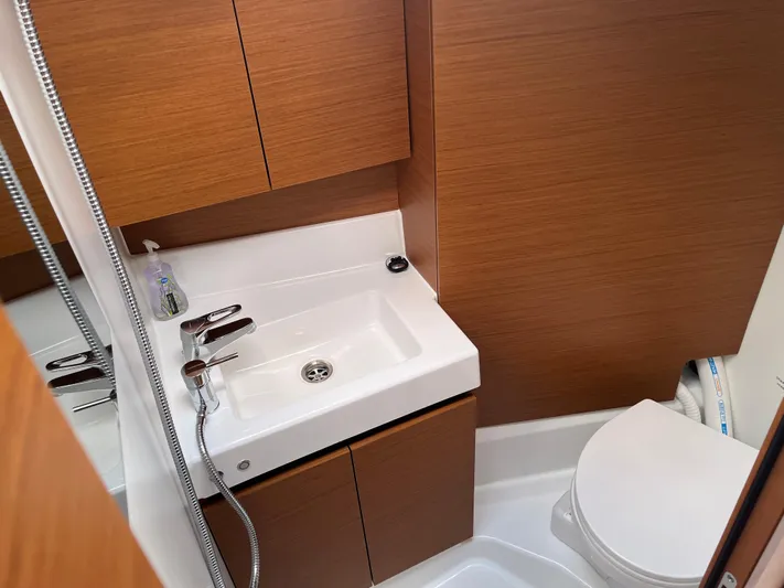 Resfeber Yacht Photos Pics Modern bathroom in 2023 Jeanneau Sun Odyssey 380 yacht, featuring sleek sink and toilet.