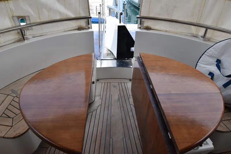 Vesuvio Yacht Photos Pics Interior of 2007 Pacific Prestige 170 yacht with wooden tables and seating area.