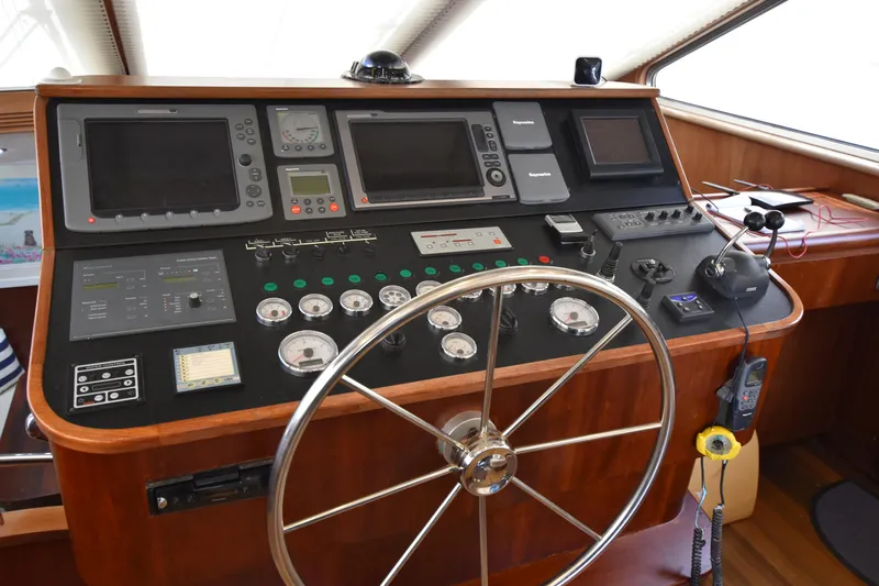 Vesuvio Yacht Photos Pics Control panel of a 2007 Pacific Prestige 170 yacht with steering wheel and navigation instruments.