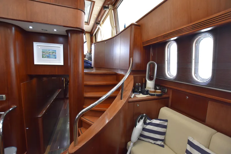 Vesuvio Yacht Photos Pics Luxurious interior of 2007 Pacific Prestige 170 yacht with wooden staircase and cozy seating area.