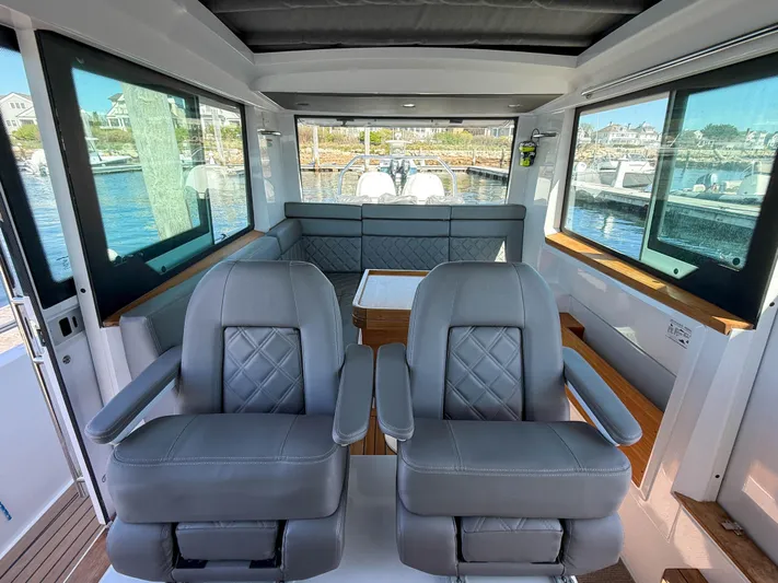 Essi Yacht Photos Pics 2019 Axopar 37 Cabin interior with plush seating and panoramic windows.