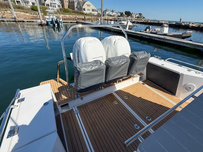 Essi Yacht Photos Pics 2019 Axopar 37 Cabin boat with sleek seating, docked in a scenic marina.