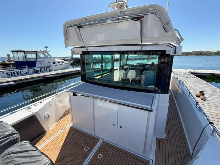 Essi Yacht Photos Pics 2019 Axopar 37 Cabin boat docked, featuring sleek design and spacious deck area.