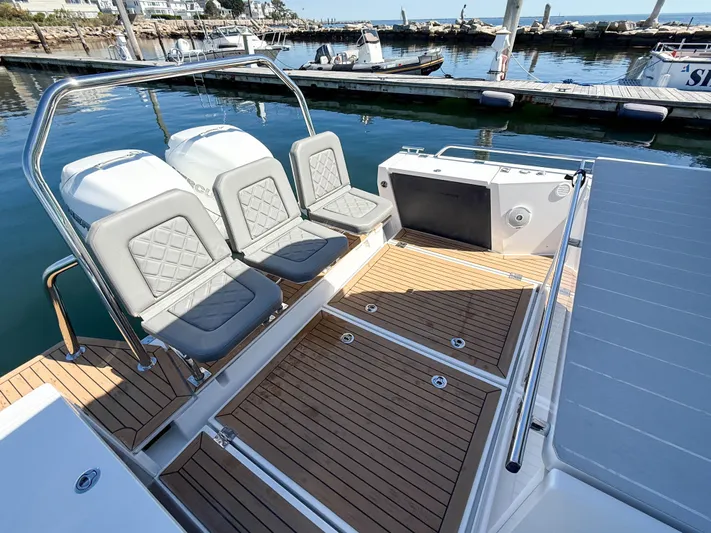 Essi Yacht Photos Pics 2019 Axopar 37 Cabin boat with sleek seating and wooden deck at marina.