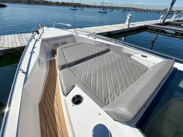 Essi Yacht Photos Pics 2019 Axopar 37 Cabin boat with cushioned deck, docked at a marina.