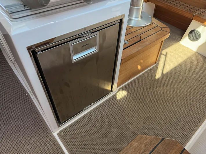 Essi Yacht Photos Pics Interior of 2019 Axopar 37 Cabin showing a compact stainless steel refrigerator.
