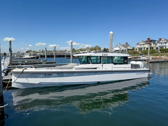 Essi Yacht Photos Pics 2019 Axopar 37 Cabin boat docked in a marina under clear blue skies.