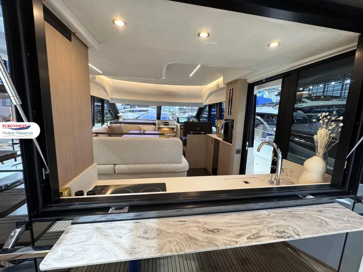 Yacht Photos Pics Luxurious interior of 2025 Prestige F4.3 yacht with modern kitchen and seating area.