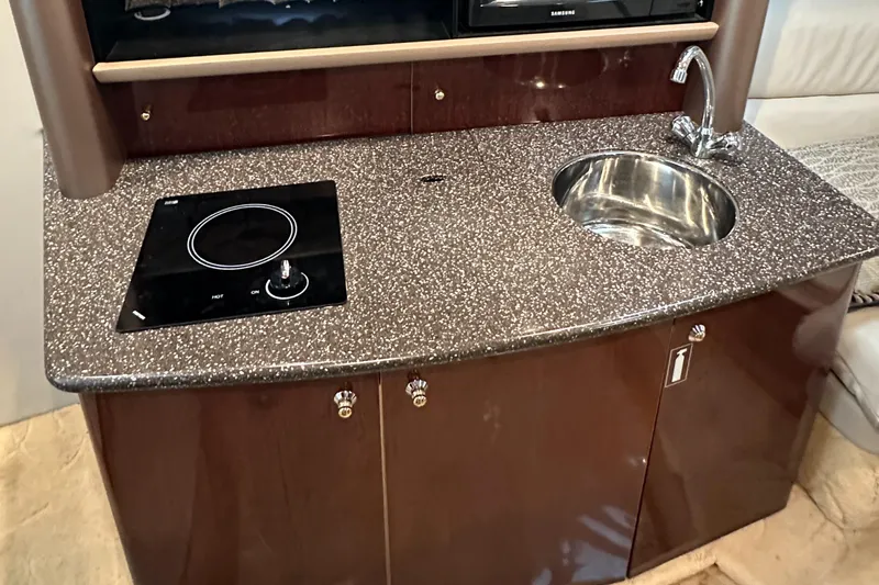  Yacht Photos Pics Compact kitchenette in 2004 Formula 370 SS boat with sink and stovetop.