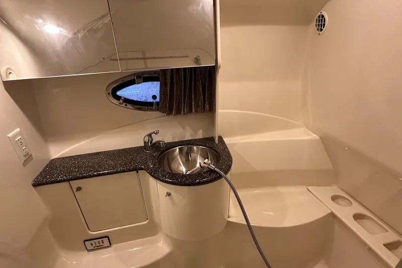 Yacht Photos Pics Luxurious 2004 Formula 370 SS boat bathroom with sink, countertop, and porthole window.