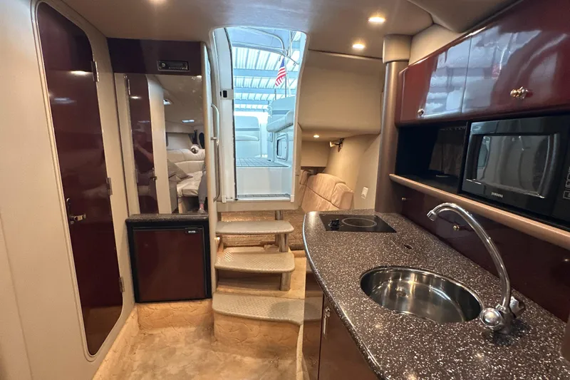  Yacht Photos Pics 2004 Formula 370 SS yacht interior with kitchenette, sink, microwave, and stairs leading to cabin.