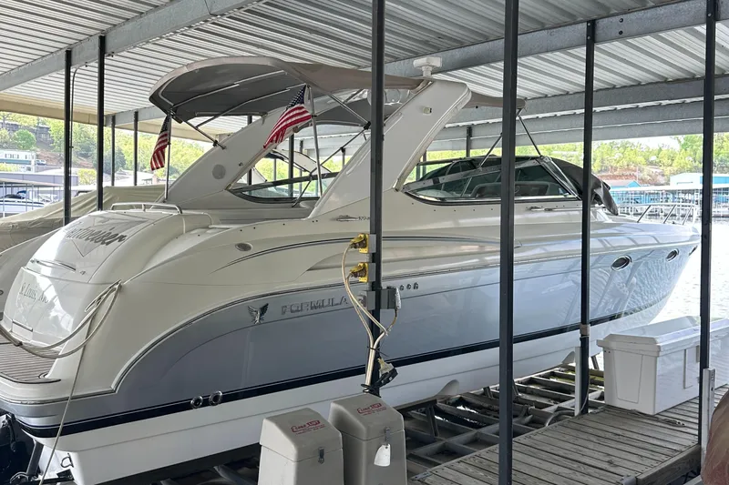  Yacht Photos Pics 2004 Formula 370 SS boat docked under a covered marina with American flags.
