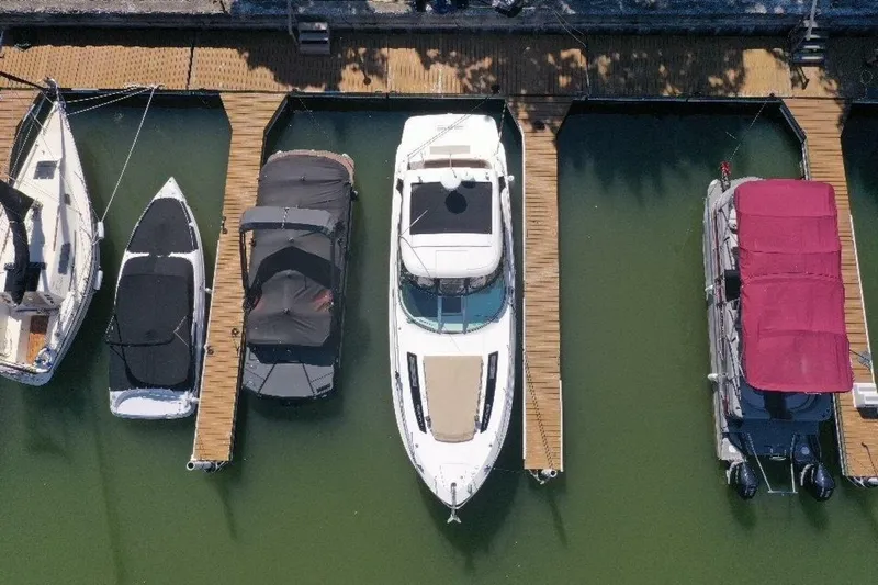  Yacht Photos Pics Aerial view of a 2016 Sea Ray 350 Sundancer docked among other boats.
