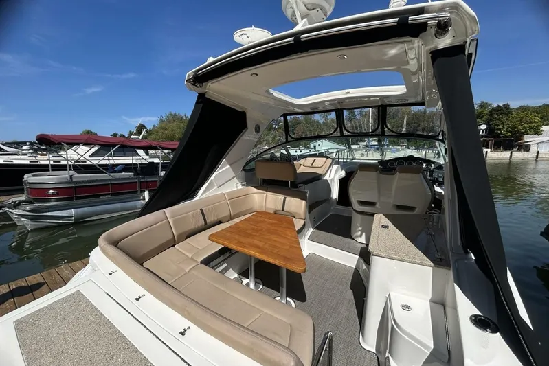  Yacht Photos Pics 2016 Sea Ray 350 Sundancer boat interior with seating and table, docked at marina.