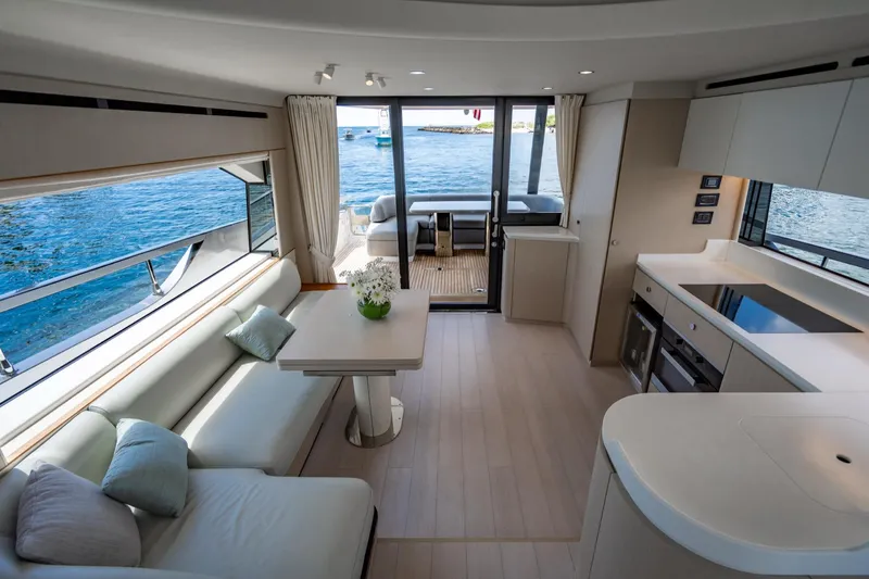 Effortless Yacht Photos Pics Luxurious interior of 2023 Azimut Fly 68 yacht with modern kitchen and seating area.