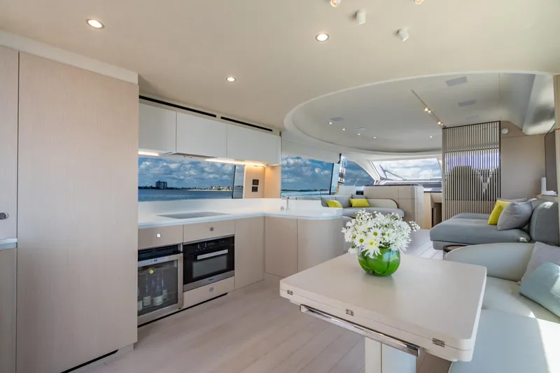 Effortless Yacht Photos Pics Luxurious interior of 2023 Azimut Fly 68 yacht with modern kitchen and seating area.