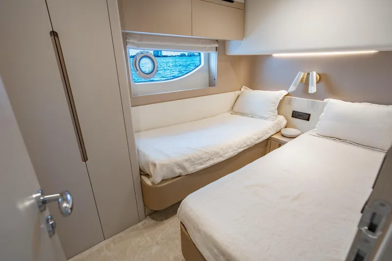 Effortless Yacht Photos Pics Luxurious cabin interior of 2023 Azimut Fly 68 yacht with twin beds and ocean view.