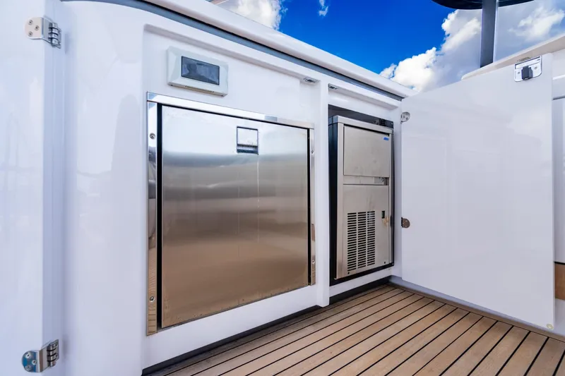 Effortless Yacht Photos Pics 2023 Azimut Fly 68 yacht deck with stainless steel appliances and wooden flooring.