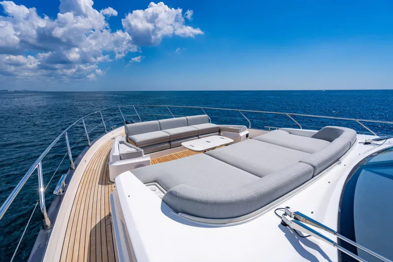 Effortless Yacht Photos Pics Luxurious 2023 Azimut Fly 68 yacht deck with plush seating, ocean view, and clear blue sky.