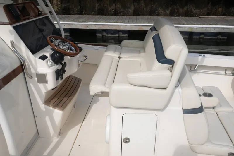 Malihini Yacht Photos Pics 2019 Hunt Yachts 32 Center Console interior with white seating and wooden steering wheel.