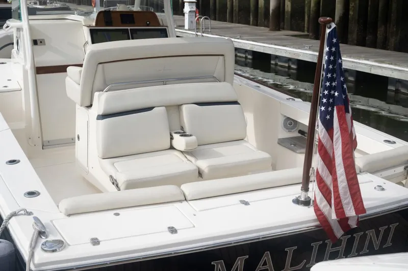 Malihini Yacht Photos Pics 2019 Hunt Yachts 32 Center Console with American flag, docked, featuring luxurious seating.