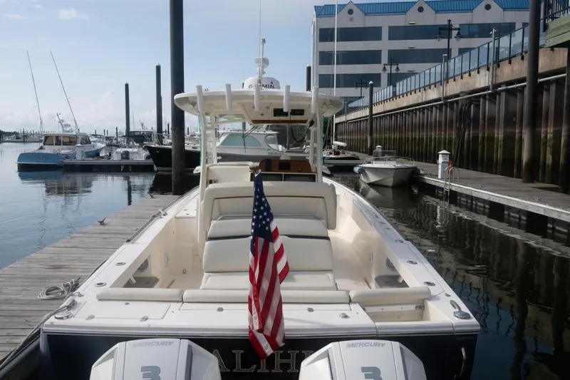 Malihini Yacht Photos Pics 2019 Hunt Yachts 32 Center Console docked, featuring American flag and twin Mercury engines.